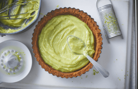 Vegan Key Lime Pie filling being spread into the biscuit base
