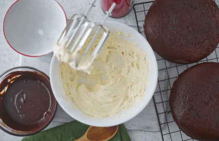 Vegan Chocolate Fudge Cake frosting being made in a bowl with a mixer
