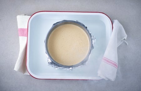 cheesecake batter in tin, surrounded by hot water
