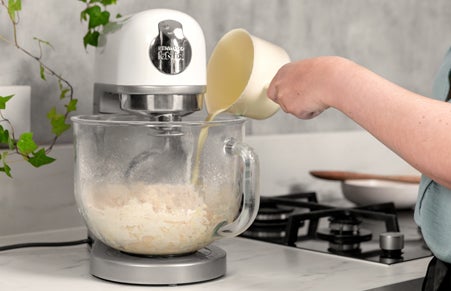 Pouring doughnut liquid mixture into the mixer