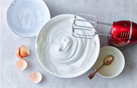 Pavlova egg whites being whisked in a bowl