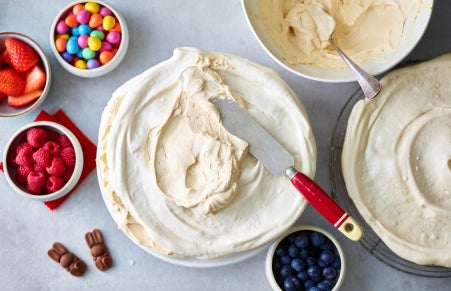 Pavlova being assembled with meringue and cream