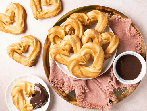 Heart shaped churros with chocolate sauce for Valentines Day